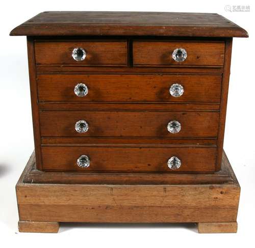 A Victorian oak miniature chest with two short and three long drawers, on associated oak base, 48cms