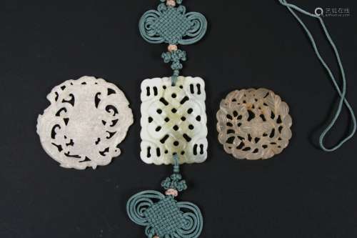 A Chinese pierced pale green hardstone pendant on an ornate blue silk cord; together with two