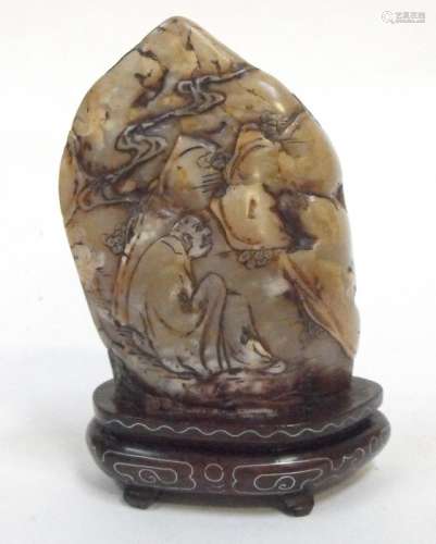 A Chinese hardstone boulder carved with figures in a landscape and mounted on a silver wire inlaid