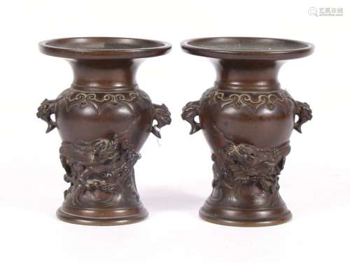 A pair of late 19th century Japanese two-handled bronze vases decorated in relief with coiled