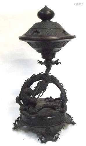 A 19th century Japanese bronze incense burner, the pierced cover with gold splash interior, on