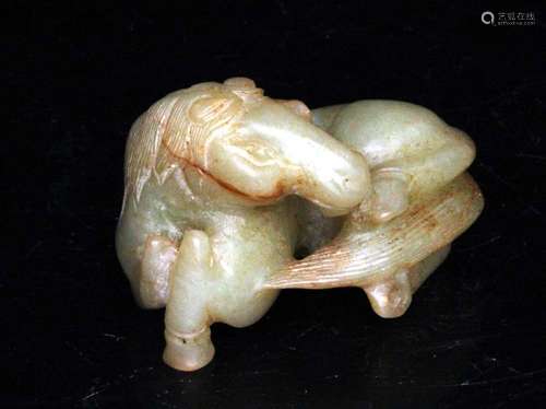 A Chinese carved jade figure in the form of a recumbent horse, 6cms (2.25ins) wide.