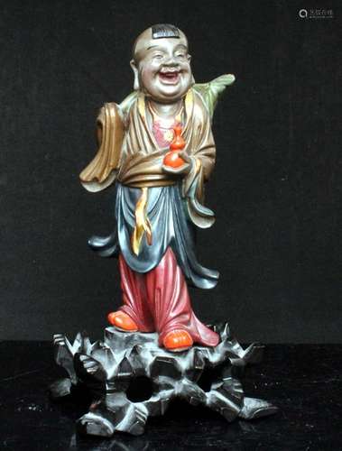 A Chinese Foochow lacquer wood figure of a boy holding a double gourd vase, 21cms (8.25ins) high.