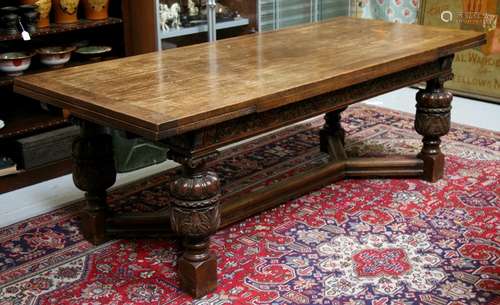 A large Jacobean style oak draw-leaf refectory table on twin carved bulbous legs joined by a