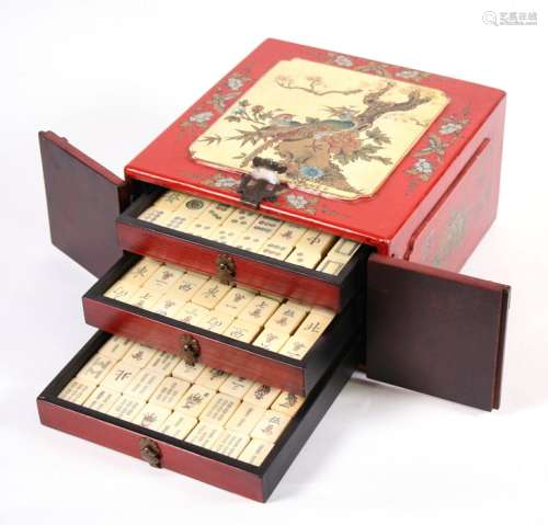 A Chinese bone and bamboo Mah Jong set in a lacquered wooden box decorated with birds, butterflies