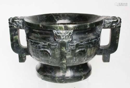 A Chinese spinach green jade two-handled censer with dragon mask capped handles, 23cms (9ins) wide.