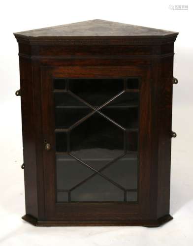 A glazed oak corner cupboard. 69cm (27.25ins) wide