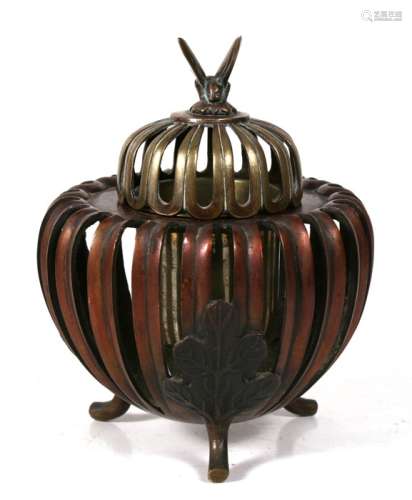 A Japanese bronze censer with openwork sides and lid and butterfly finial, on three leaf capped