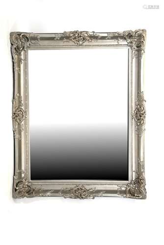 A large modern ornate silver framed bevel edge mirror, 122cms (48ins) wide.