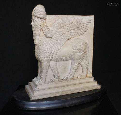 An Assyrian human winged lion mounted on an ebonised plinth (after the antique) 23cms (9ins) high.