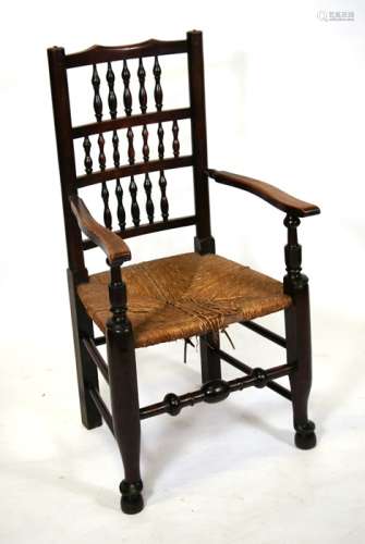 A Lancashire spindle back carver chair with rush seat.