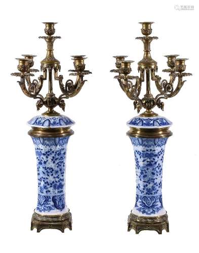 A pair of Continental blue and white glazed porcelain and brass mounted five light candelabra, early