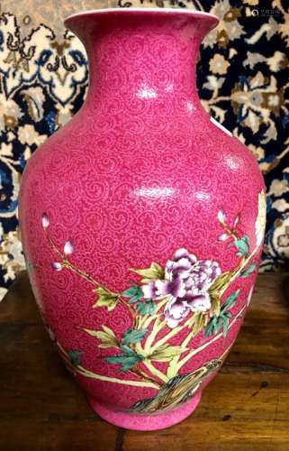 A Chinese ruby ground, famille rose vase with trumpet neck, decorated with a pair of birds on a