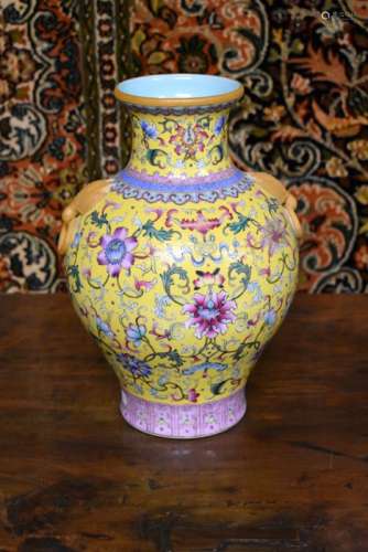 A Chinese famille rose vase decorated with floral designs on the yellow ground, 28 cm high; the base