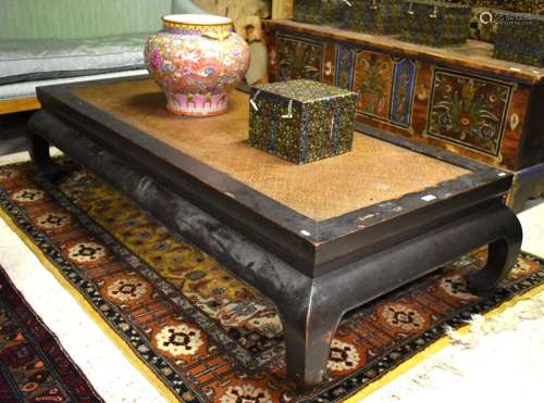 A Chinese rattan panelled lacquered hardwood daybed in the Ming style, raised on four scroll feet,