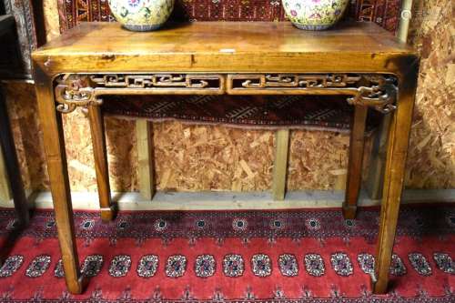 An antique Chinese elm table, the rectangular top over a pierced fret cut frieze, raised on four