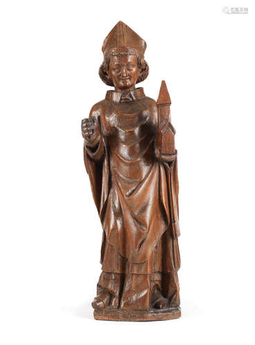 An 18th century carved walnut figure of a male saint, possibly St Eligius, German or French