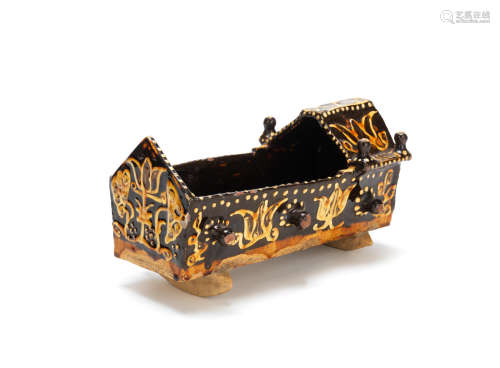 An English slipware model of a cradle, probably Staffordshire, circa 1690-1700