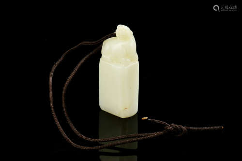 A CELADON JADE CARVED STAMP SEAL WITH STRING
