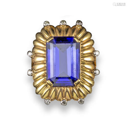A synthetic sapphire and diamond ring, the emerald-cut synthetic sapphire is set within fluted