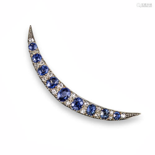 An Edwardian sapphire and diamond-set open crescent brooch, set with graduated oval-shaped sapphires
