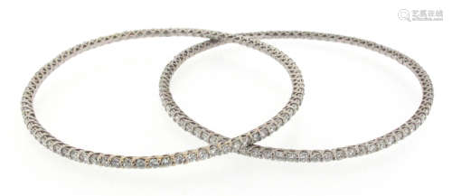 A pair of diamond-set white gold bangles, each set with a full circle of round brilliant-cut