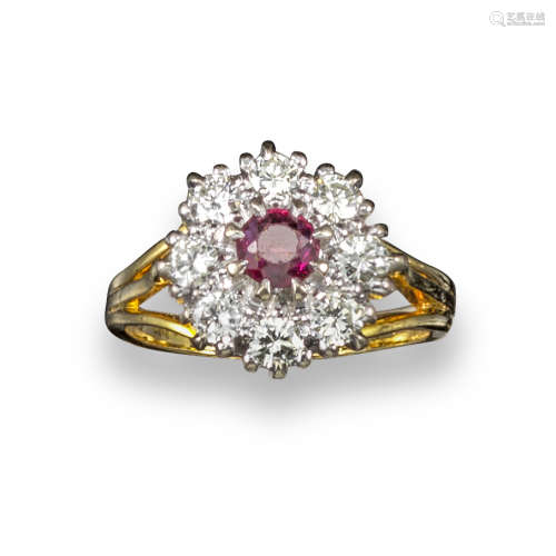 A ruby and diamond cluster ring, the circular-cut ruby set within a surround of eight circular-cut