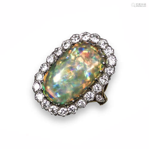 An opal and diamond cluster ring, the solid white opal cabochon is set within a surround of