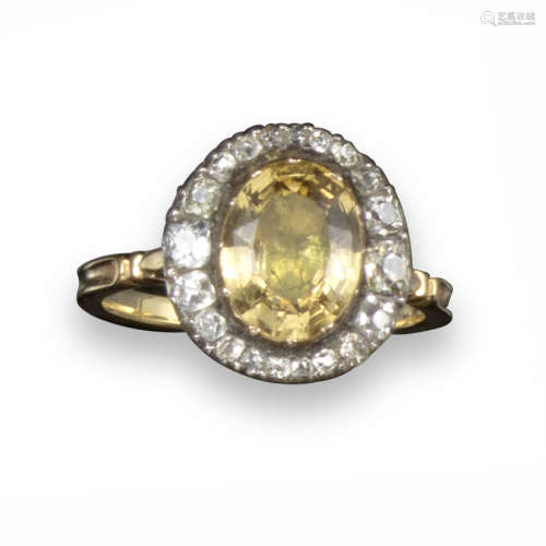 A George III topaz and diamond ring, the oval-shaped topaz is set within acentric surround of