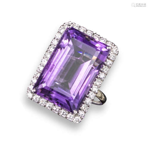 An amethyst and diamond ring, the rectangular step-cut amethyst is set within a surround of round