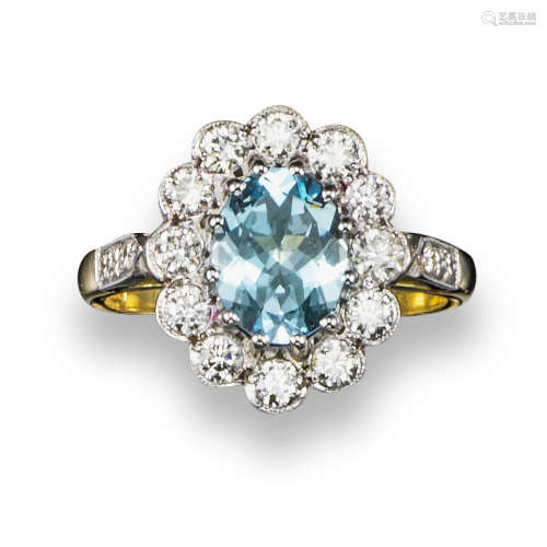 An aquamarine and diamond cluster ring, the oval-shaped aquamarine is set within a surround of