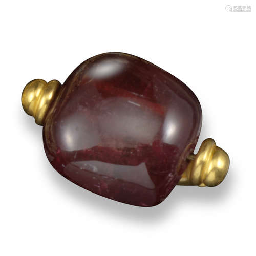 A pink tourmaline ring, the large tourmaline bead spins in a yellow gold hammered effect mount,