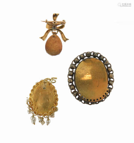An oval-shaped garnet-mounted gold pendant, suspending from a bow with remnants of green enamel