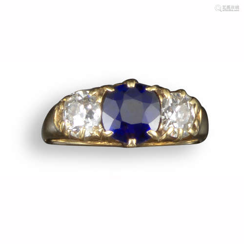 A late 19th century sapphire and diamond three-stone ring, the cushion-shaped sapphire flanked