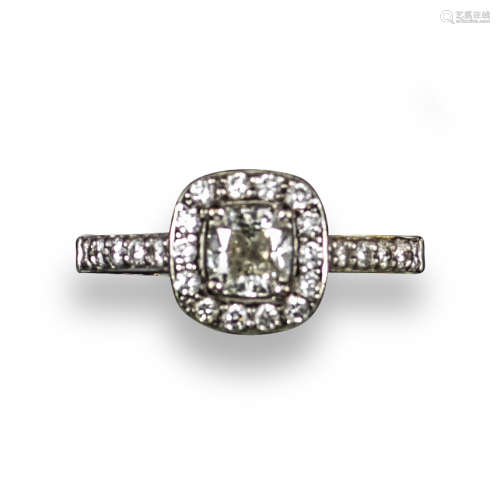 A diamond cluster ring, the central cushion-shaped diamond weighs 0.70cts and is set within a