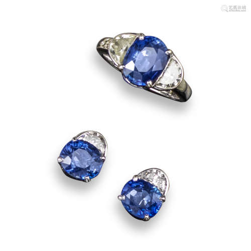 A sapphire and diamond three stone ring, the oval shaped sapphire is set with two half-moon-shaped
