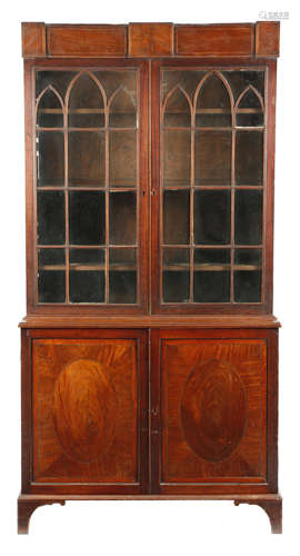 A Regency mahogany and satinwood bookcase cabinet, inlaid with stringing, the detachable cornice