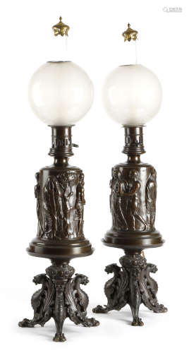 A pair of late 19th century French bronze table lamps, each with a globe shade above a body cast