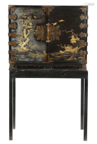 A Japanese black lacquer cabinet, with engraved copper strapwork mounts and hinges, with a pair of