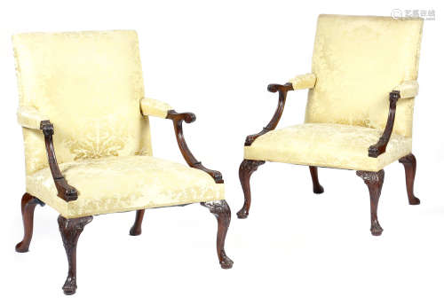 A pair of mahogany library armchairs in George II style, each with a padded back, armrests and seat,