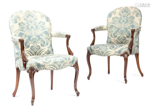A pair of George III mahogany open armchairs in French Hepplewhite style, each with a padded back,