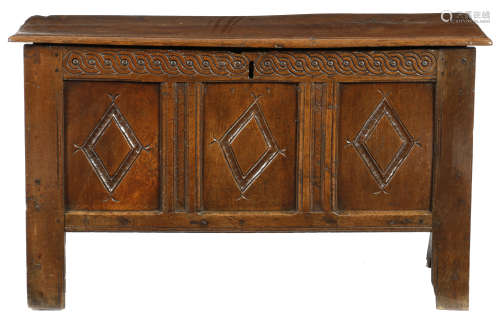 An oak coffer, the hinged top with a moulded edge above a guilloche carved frieze and triple