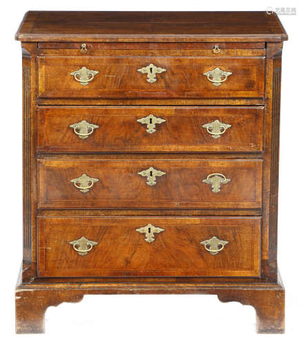 A small walnut chest in George II style, the quarter veneered top with cross and feather banding,