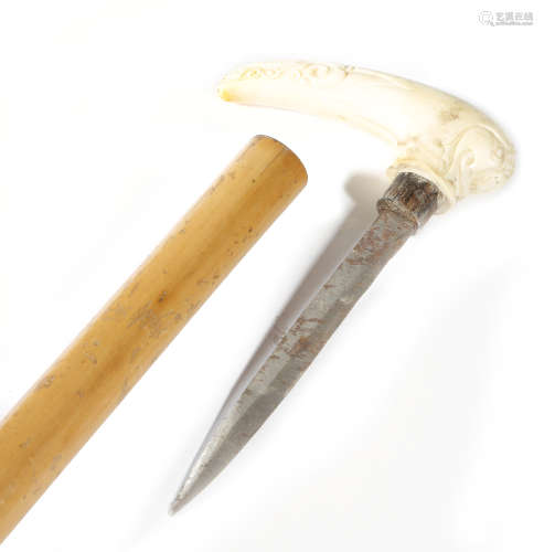 λ A Victorian ivory handled walking cane, the handle carved with scrolls and with a snake head which