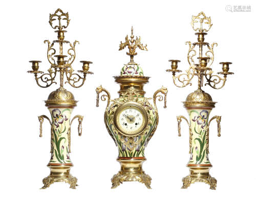 A French pottery and gilt brass clock garniture, the eight day brass cased drum movement striking on