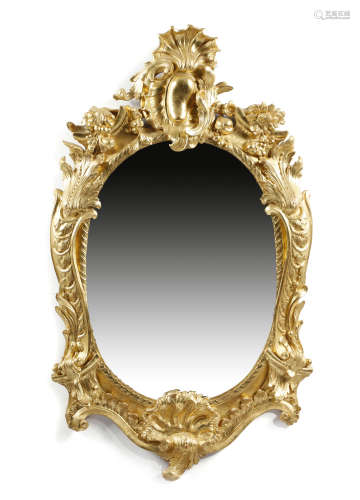 A giltwood and composition wall mirror in 18th century style, the oval plate within a Rococo