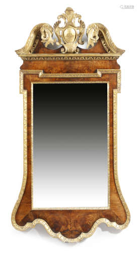 A George II style walnut and parcel gilt wall mirror, the later rectangular bevelled plate within