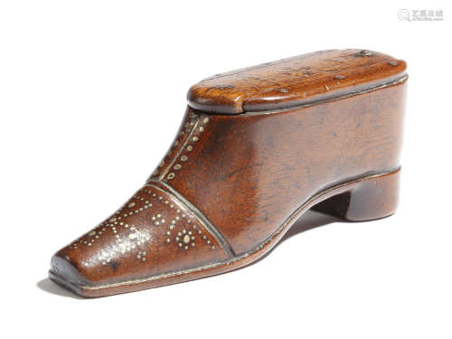 A 19th century treen snuff shoe, with brass tack decoration and a sliding cover, 11cm long.