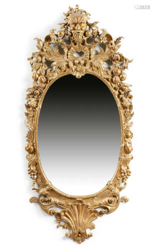 A giltwood wall mirror in the manner of Matthias Lock, the oval plate within a moulded slip, the
