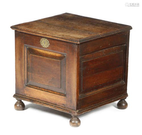 An early 18th century oak closed stool, the hinged top with a moulded edge above a vacant interior